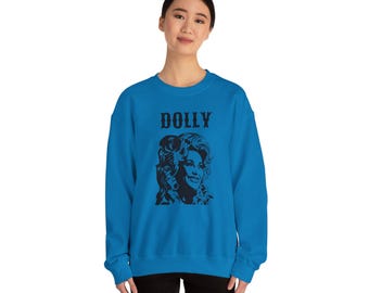 Op de afbeelding: Een felblauw sweatshirt met een zwart silhouet van Dolly Parton en het woord "DOLLY" erop gedrukt.