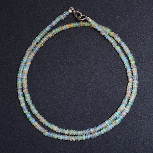 Puede incluir: Un delicado collar hecho de cuentas de ópalo iridiscente. El collar es de doble cadena y tiene un cierre de plata.