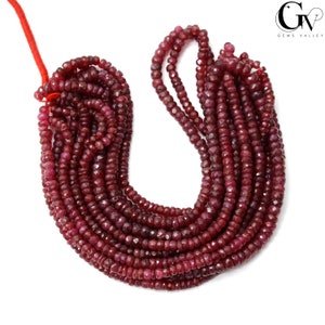 Könnte beinhalten: Eine Strähne aus rubinroten Edelsteinperlen. Die Perlen sind facettiert und haben eine leicht unregelmäßige Form. Die Strähne ist etwa 45 cm lang.