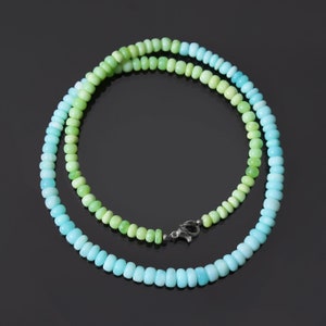 May include: A double-strand necklace made of green and blue gemstone beads. The beads are graduated in size, with the larger beads at the bottom of the necklace. The necklace is secured with a silver clasp.