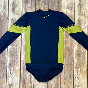 May include: A navy blue long-sleeved leotard with yellow accents on the sleeves and sides. The leotard has a round neckline and is decorated with rhinestones.