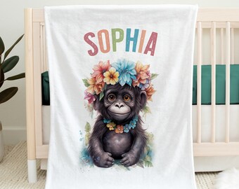 Könnte beinhalten: Eine weiße Fleece-Decke mit einem schwarzen Affen, der eine Blumenkrone und eine Blumenkette trägt. Der Affe sitzt auf einem Blumenbeet. Der Name "SOPHIA" ist in Regenbogenfarben oben auf der Decke geschrieben.