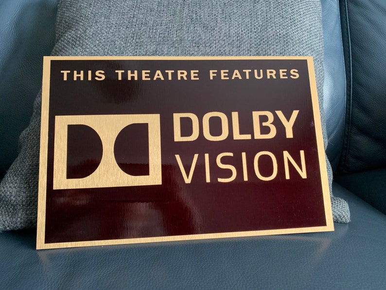May include: A gold plaque with the text "This theatre features Dolby Vision" on a dark red background.