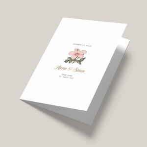 Może przedstawiać: Białe zaproszenie ślubne z ilustracją różowego kwiatu hibiskusa. Tekst brzmi "Velkommen til vielse" po którym następuje "Maria & Simon", "Onsøy Kirke" i "23. August 2023".