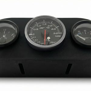 May include: A black dashboard gauge pod with three circular gauges. The center gauge reads up to 3.0, with a red needle. The left gauge shows a fuel level, and the right gauge displays temperature in Celsius.