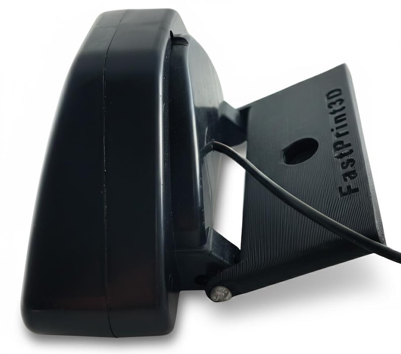 May include: A black 3D printer component with the text "FastPrint3D" on a rectangular base. The component has a curved, rounded top and a small hole. A black wire extends from the base.