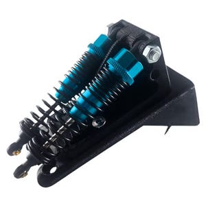 May include: A black suspension system with two blue shock absorbers and black springs. The system has a mounting bracket and is designed for a small vehicle or model.