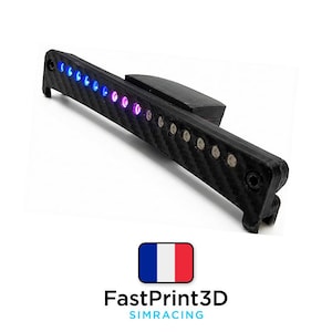 Può includere: Un dispositivo elettronico nero con texture in fibra di carbonio con una serie di luci a LED multicolore. Il dispositivo ha una forma rettangolare con un piccolo componente collegato. Il testo "FastPrint3D SIMRACING" è sotto una bandiera francese.