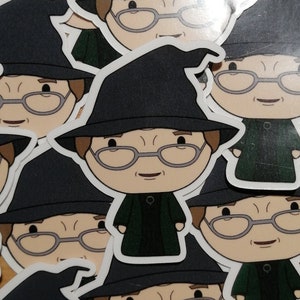 May include: A set of stickers featuring a cartoon character wearing a black witch hat and green robes. The character has glasses and a friendly expression.