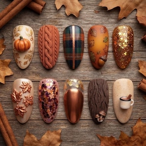May include: Ten almond-shaped press-on nails featuring autumn designs including a 3D pumpkin, orange cable knit texture, green and orange plaid, falling leaves with an acorn, gold glitter, copper leaves, multicolored sequins, metallic copper, brown bark texture with mushrooms, and a mug.