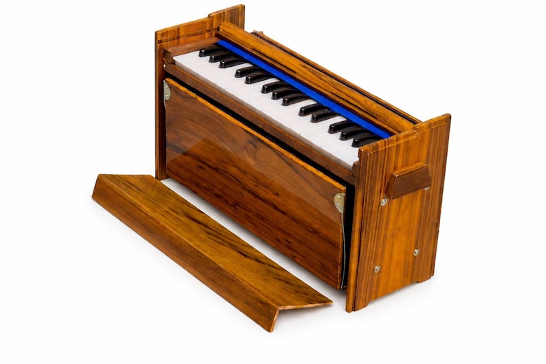 Pode incluir: Um harm&oacute;nio de madeira com acabamento brilhante. O instrumento apresenta um teclado com teclas pretas e brancas, um detalhe azul e um painel de madeira remov&iacute;vel. O harm&oacute;nio foi concebido para atua&ccedil;&atilde;o musical.