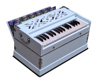May include: A white wooden harmonium with a keyboard and bellows. The harmonium has a decorative carved design on the top and silver accents.