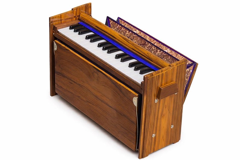 Pode incluir: Um harm&ocirc;nio de madeira com um teclado de teclas pretas e brancas. O instrumento tem um acabamento rico e quente de gr&atilde;o de madeira. Uma faixa azul adorna a parte superior das teclas. O fole &eacute; vis&iacute;vel com um tecido estampado.