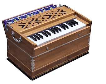 May include: A wooden harmonium with a keyboard of black and white keys. The instrument has a decorative carved top and silver metal accents. The bellows are visible on the left side, and the overall design is traditional.