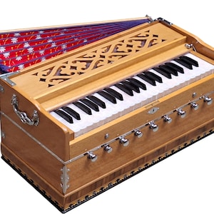 May include: A wooden harmonium with a keyboard and bellows. The instrument has a light brown finish, decorative carvings, and silver-colored knobs. The bellows are red with a white floral pattern. The keyboard has black and white keys.