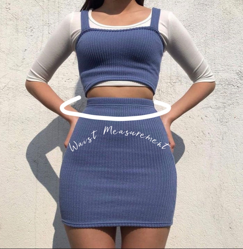 Puede incluir: Un conjunto de top corto y falda a juego de color azul con textura de canal&eacute;. El top tiene cuello redondo y tirantes finos. La falda es una minifalda de talle alto. El conjunto se muestra en una modelo con una camiseta blanca debajo.