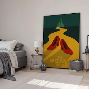 Könnte beinhalten: Gerahmtes Poster mit einer stilisierten Illustration aus "Der Zauberer von Oz". Das Kunstwerk zeigt eine gelbe Ziegelstraße, die zu einer grünen Stadt führt, mit einem Paar roter High-Heel-Schuhe im Vordergrund. Der Titel "THE WIZARD OF OZ" ist in weißen Buchstaben gedruckt.