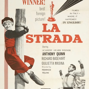 May include: A movie poster for the film "La Strada" starring Anthony Quinn, Richard Basehart, and Giulietta Masina. The poster features a black and white image of the actors and the film's title in red letters. The poster also includes the text "Academy Award Winner!" and "Filmed in Italy - Where it Happened! In English!"