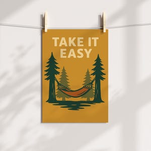 May include: A mustard-coloured poster with the words "TAKE IT EASY" in white. The image features a hammock strung between two pine trees, with a forest backdrop. The hammock is orange and brown.