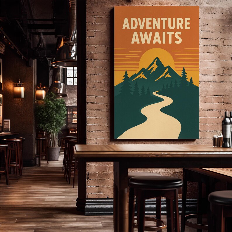 May include: A framed canvas print with the words "ADVENTURE AWAITS" in white block letters. The artwork depicts a mountain range, a winding path, and a setting sun in orange, green, and yellow. The print is displayed in a restaurant setting.
