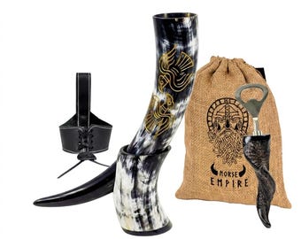 May include: A drinking horn with gold-colored bird engravings, a black leather lace-up holder, a burlap drawstring bag with a printed bearded figure and the text "NORSE EMPIRE," and a small horn-handled bottle opener with a metal top.