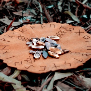 Pu&ograve; includere: Una sacca di cuoio con rune incise sulla superficie. Un mucchio di rune di legno si trova al centro della sacca.