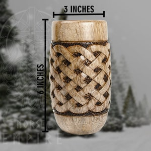 May include: A wooden drinking cup with a Celtic knot design. The cup is 6 inches tall and 3 inches wide.