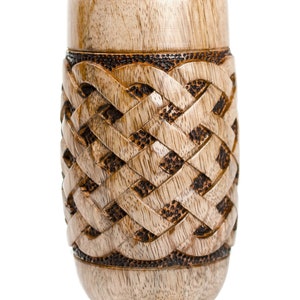 May include: A wooden vase with a carved Celtic knot design. The vase is light brown with dark brown accents.