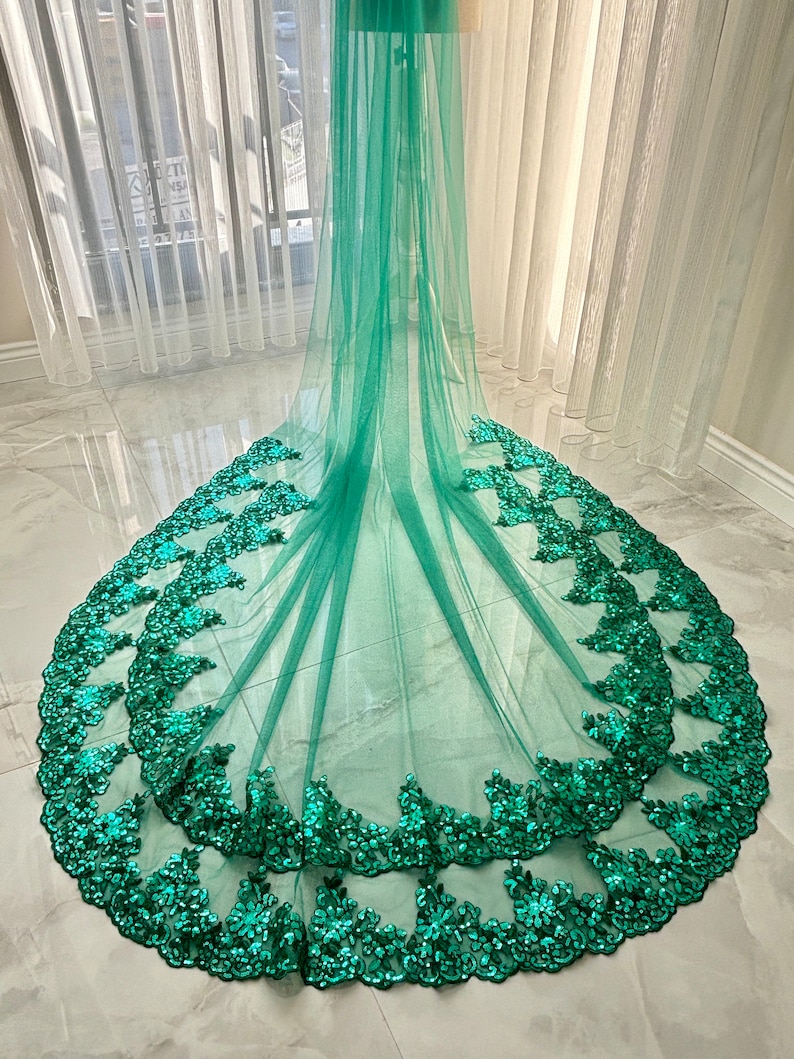May include: A teal green tulle veil with a scalloped edge and a double layer of emerald green sequin trim.