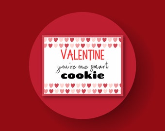 May include: White card with a red heart border and the text "VALENTINE you're one smart cookie" in black and red lettering.