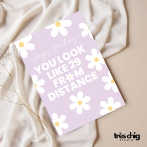 Könnte beinhalten: Eine lila Karte mit weißen Gänseblümchen darauf gedruckt. Die Karte sagt "Happy Birthday" und "Du siehst aus wie 29 aus der Ferne".