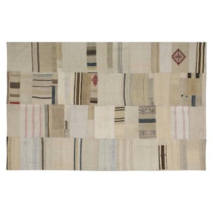 Pode incluir: Um tapete retangular de patchwork em tons neutros. O tapete é composto por várias peças retangulares em tons de bege, creme e castanho, com listras sutis e padrões geométricos em marrom, azul e vermelho. O tapete tem uma estética vintage e artesanal.