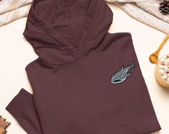 May include: A dark maroon hooded sweatshirt featuring an embroidered whale shark patch on the upper left chest. The hoodie has long sleeves with ribbed cuffs, a front kangaroo pocket, and a hood with a thick, structured collar design.