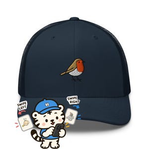 Peut inclure: Une casquette trucker bleu marine avec un rouge-gorge brodé sur le panneau avant. La casquette possède un devant solide et un arrière en filet. Un personnage de tigre est situé en bas avec le texte SWIPE LEFT et SWIPE RIGHT.