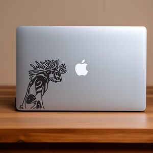 Könnte beinhalten: Ein schwarz-weißer Aufkleber mit einer stilisierten Kreatur mit einer stacheligen Mähne auf einem silbernen Laptop.