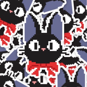 Puede incluir: Un gato negro con orejas azules y una pajarita roja. El gato está pixelado y tiene un estilo de dibujos animados. La imagen es una hoja de pegatinas con varias copias del gato.