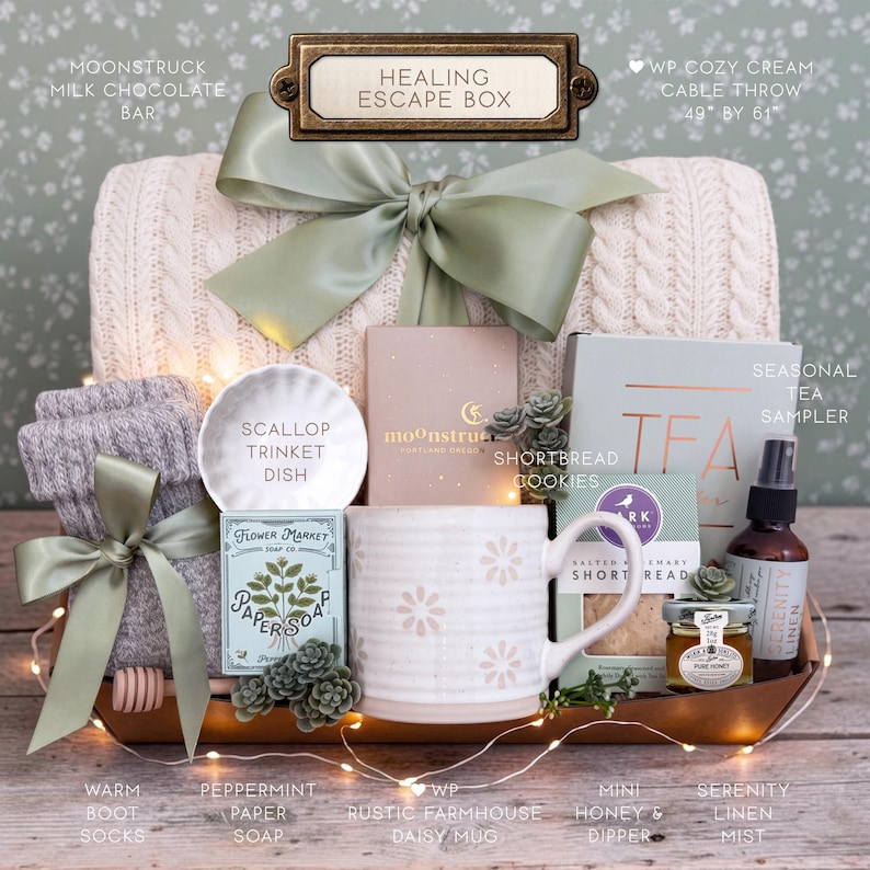Op de afbeelding: Een geschenkset met het label Healing Escape Box, bestaande uit een cr&egrave;me kabelgebreide plaid van 124 bij 155 cm, een mok met madeliefjespatroon, een geschulpt schaaltje, pepermuntpapierzeep, zandkoekjes, honing, een dipper en linnenspray.