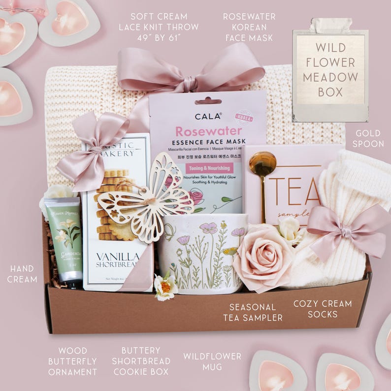 May include: A gift basket with a soft cream lace knit throw (49" x 61"), a Rosewater Korean face mask, a wildflower mug, and a box of vanilla shortbread cookies. The basket also includes a gold spoon, cozy cream socks, and a wood butterfly ornament.