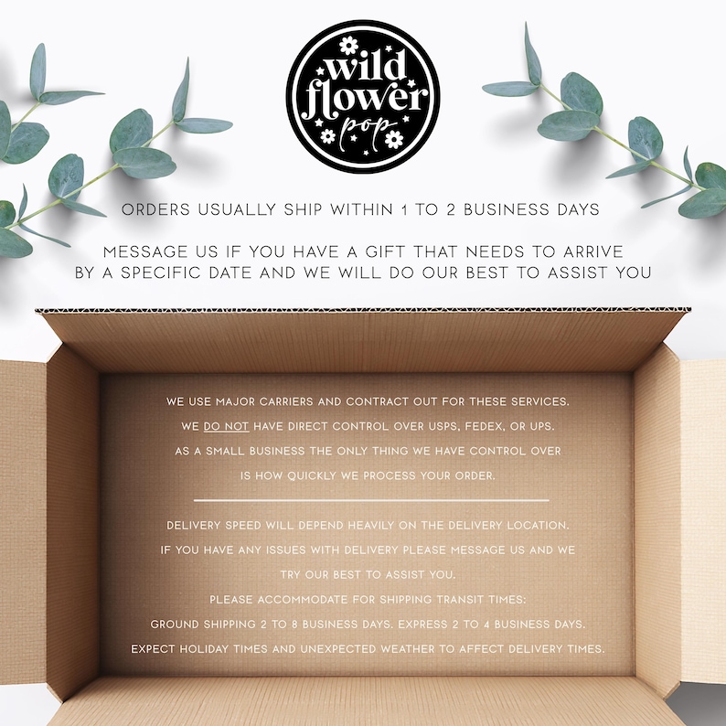 May include: An open brown cardboard shipping box with text printed on the interior base and top. The top features a circular black logo with the text wildflower pop and floral icons. Green eucalyptus sprigs frame the top of the box.