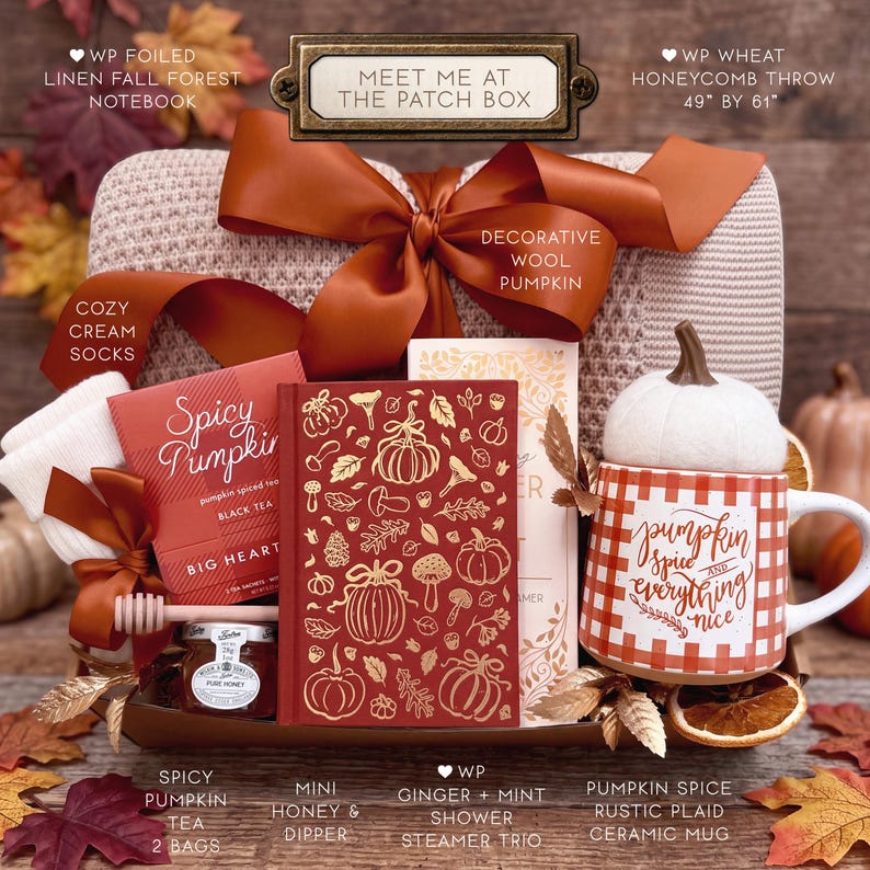 May include: A gift box containing a cream knit throw, a decorative wool pumpkin, a pair of cream socks, a box of Spicy Pumpkin tea, a notebook with gold pumpkin illustrations, a jar of honey with a dipper, shower steamers, and a plaid mug.