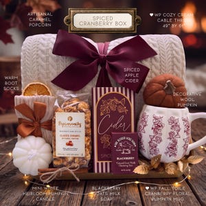 Puede incluir: Un set de regalo que incluye una manta de punto trenzado color crema de 124 cm por 155 cm, una vela blanca con forma de calabaza, palomitas de caramelo, jab&oacute;n de leche de cabra, sidra de manzana especiada y una taza con dise&ntilde;o floral.