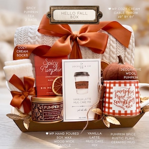 Puede incluir: Una caja de regalo Hello Fall que contiene una manta de punto trenzado blanca de 124 cm por 155 cm, calcetines crema, t&eacute; Spicy Pumpkin, una vela de soja Pumpkin Spice, mezcla para pastel, una calabaza de fieltro y una taza de cer&aacute;mica a cuadros.