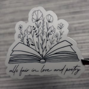 May include: A black and white sticker with a drawing of an open book with flowers growing out of it. The text "all's fair in love and poetry" is written below the book.