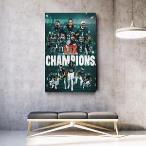May include: A group of football players in green and white uniforms holding up a trophy that says "Super Bowl Champions".