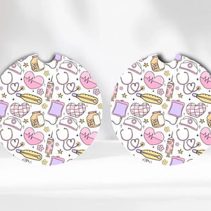May include: Two white round coasters with a pattern of pink hearts, yellow stars, white stethoscopes, and other medical symbols. The coasters are perfect for adding a touch of personality to your home.