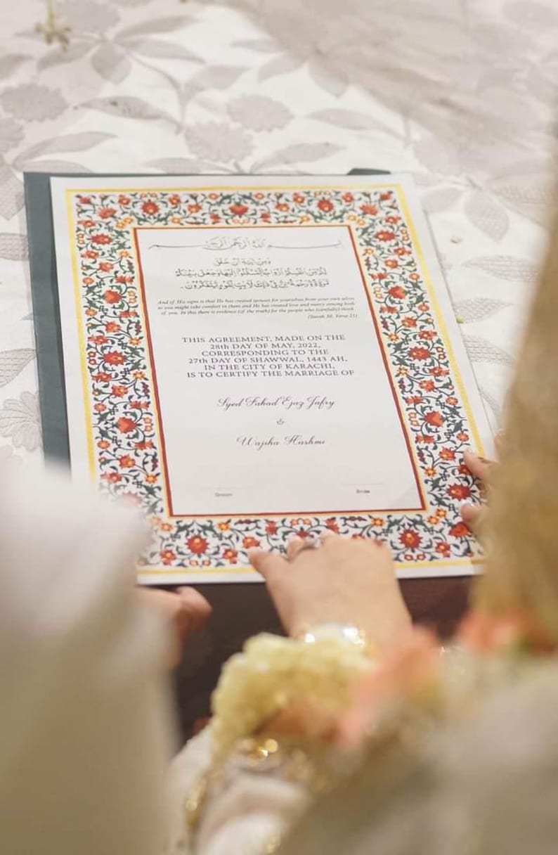 Puede incluir: Un certificado de matrimonio con un borde floral adornado en rojo, amarillo y verde. El texto dice "Este acuerdo, hecho el 28 de mayo de 2022, correspondiente al 27 de Shawwal, 1443 AH, en la ciudad de Karachi, certifica el matrimonio de Syed Fahad Ejaz Jafry y Wajiha Hashme."