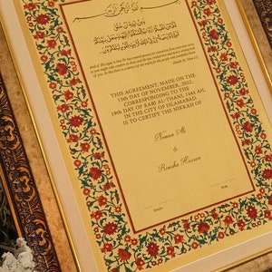 Puede incluir: Un documento enmarcado con un marco dorado ornamentado y un borde floral. El documento es un certificado de matrimonio con texto &aacute;rabe y los nombres "Noman Ali" y "Rimsha Hassan" en la parte inferior.