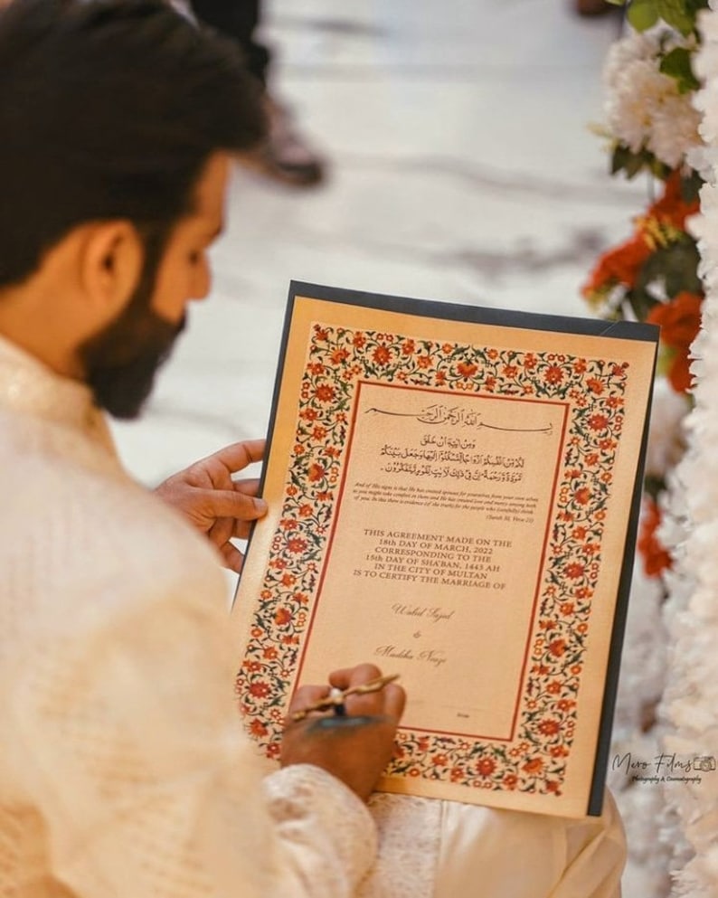 Puede incluir: Un primer plano de un documento con un borde adornado y texto en &aacute;rabe. El documento est&aacute; titulado "This Agreement Made on the 18th Day of March, 2022" y est&aacute; firmado con las palabras "Widad Syed" y "Mubba Syed".