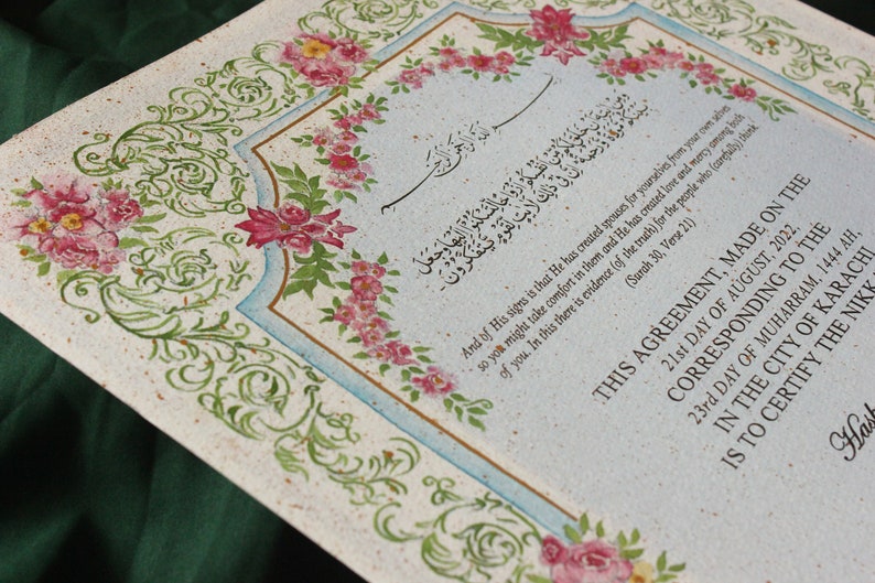 Puede incluir: Un documento decorativo con bordes florales y caligraf&iacute;a &aacute;rabe. El texto dice "Y de Sus signos est&aacute; que &Eacute;l ha creado para vosotros, de vosotros mismos, esposas para que encontr&eacute;is en ellas un consuelo, y &Eacute;l ha suscitado entre vosotros amor y misericordia. En esto hay pruebas (de la verdad) para la gente que reflexiona (Sura 30, Vers&iacute;culo 21)". El documento se titula "Este acuerdo, hecho el 21 de agosto de 2022, correspondiente al 23 de muharram 1444 AH, en la ciudad de Karachi, certifica el Nikkah".