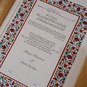 Puede incluir: Un documento enmarcado con un borde floral adornado en tonos rojos, verdes y dorados. El documento es un certificado de matrimonio, con el texto "This Agreement, Made on 21st Day of December, 2022, Corresponding to the 25th Day of Jumada Al-Awwal, 1444 AH, in the City of Khanpur, is to Certify the Nikkah of Hamza Khursheed with Safah Saddiqa."
